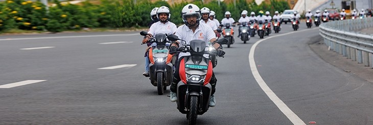 An image showing Group of people enjoying a community ride on VIDA electric scooters through scenic landscapes