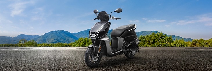 An electric scooter black in color on a city street, symbolizing clean and sustainable mobility to reduce urban pollution.